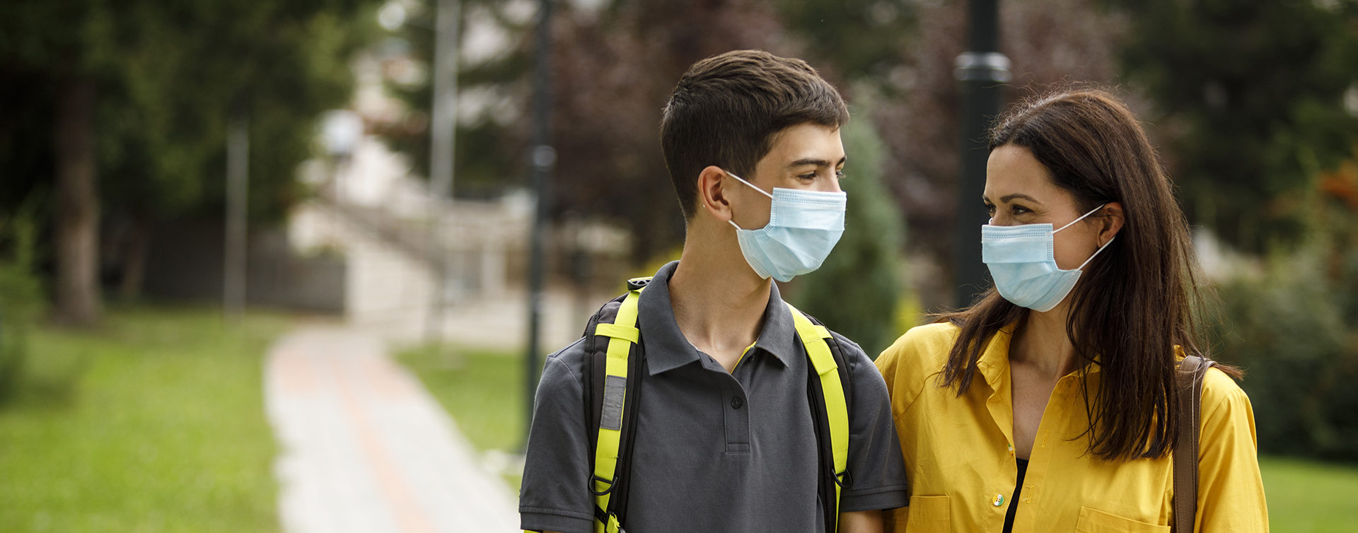 Mother and her teenage son walking and talking outdoors